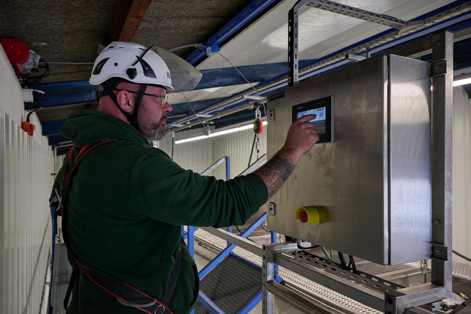 Mitarbeiter steuert die Reinigungsanlage über das Bedienpanel